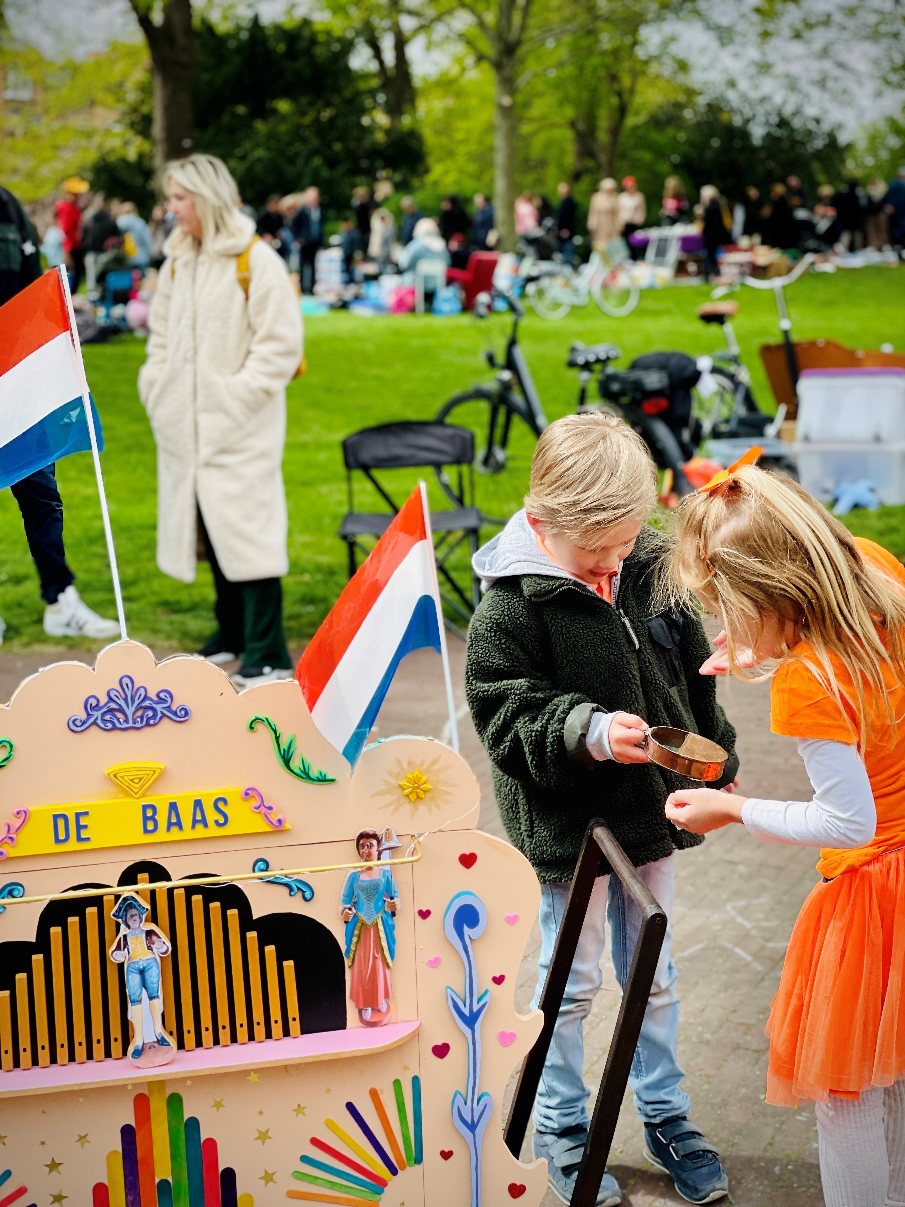 Twee kinderen tijdens Koningsdag met een draaiorgel
